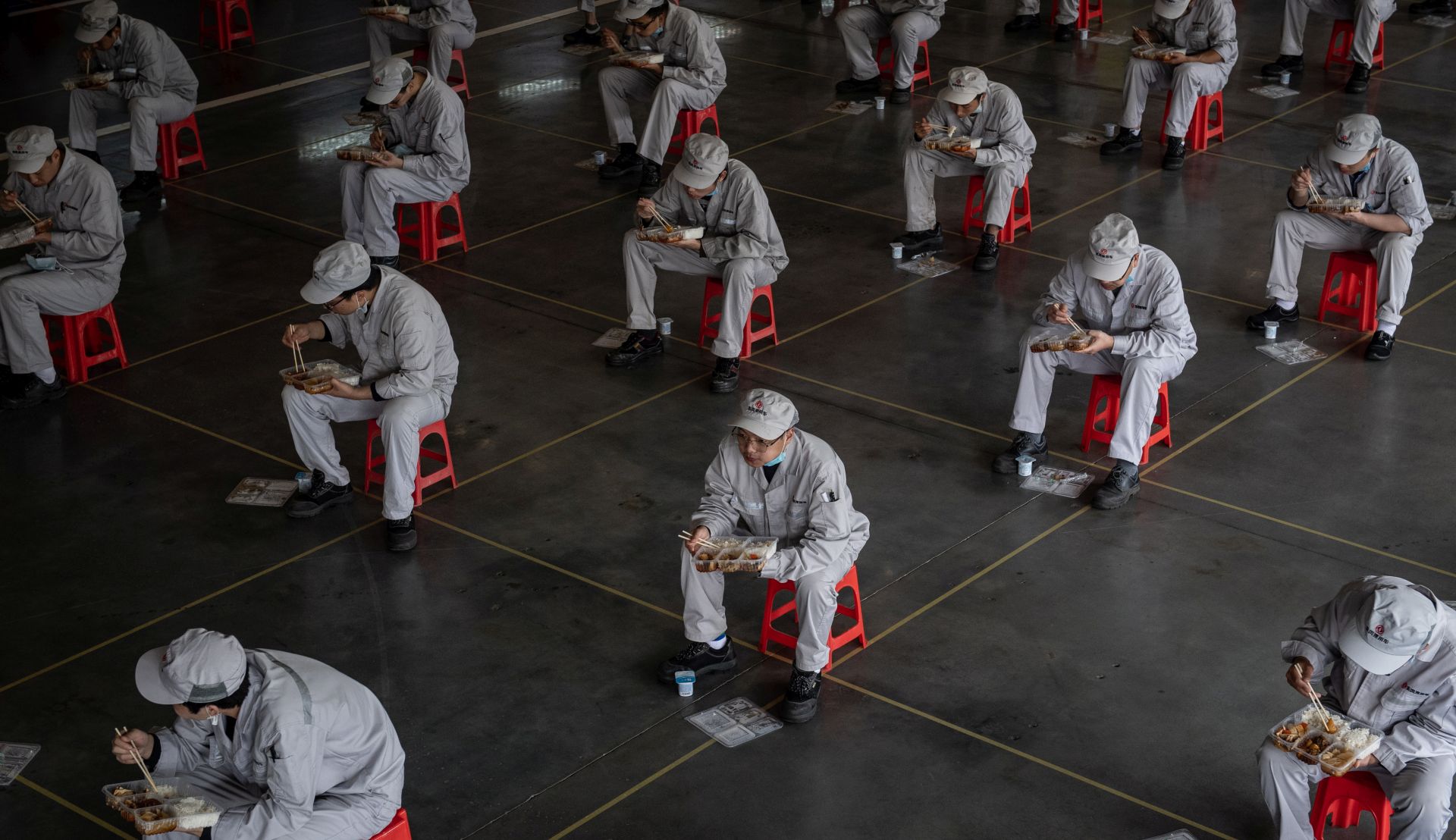 epa08317268 Workers have lunch while sitting 1.5 meters away from others at the joint-venture Dongfeng Honda in Wuhan, Hubei province, China, 23 March 2020 (issued 24 March 2020). The automaker says 95 percent of its labor force has returned to their posts after the long COVID-19 break.  EPA/Yi Xin CHINA OUT
