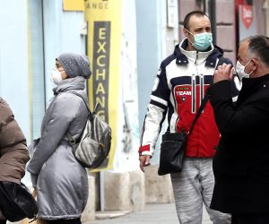epa08324279 People wearing face masks walk in a street of on Sarajevo, Bosnia and Herzegovina, 26 March 2020. Several European countries have closed borders, schools, public facilities, and have canceled most major sports and entertainment events, in order to prevent the spread of the SARS-CoV-2 coronavirus, which causes the COVID-19 disease.  EPA/FEHIM DEMIR