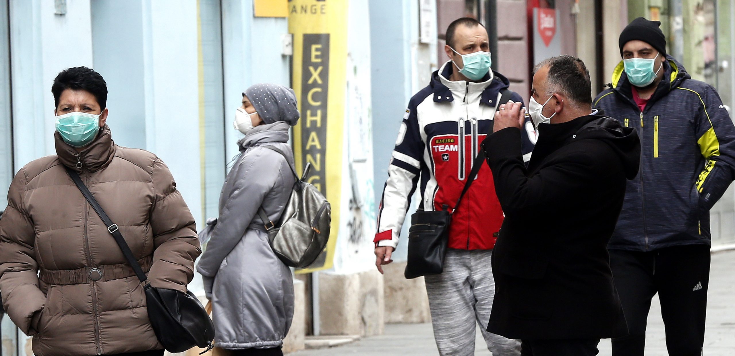epa08324279 People wearing face masks walk in a street of on Sarajevo, Bosnia and Herzegovina, 26 March 2020. Several European countries have closed borders, schools, public facilities, and have canceled most major sports and entertainment events, in order to prevent the spread of the SARS-CoV-2 coronavirus, which causes the COVID-19 disease.  EPA/FEHIM DEMIR