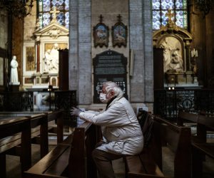epa08325054 A man wearing a protective face mask prays inside Notre Dame des Victoires basilica in Paris, France, 26 March 2020. France is under lockdown in an attempt to stop the widespread of the SARS-CoV-2 coronavirus causing the Covid-19 disease.  EPA/YOAN VALAT