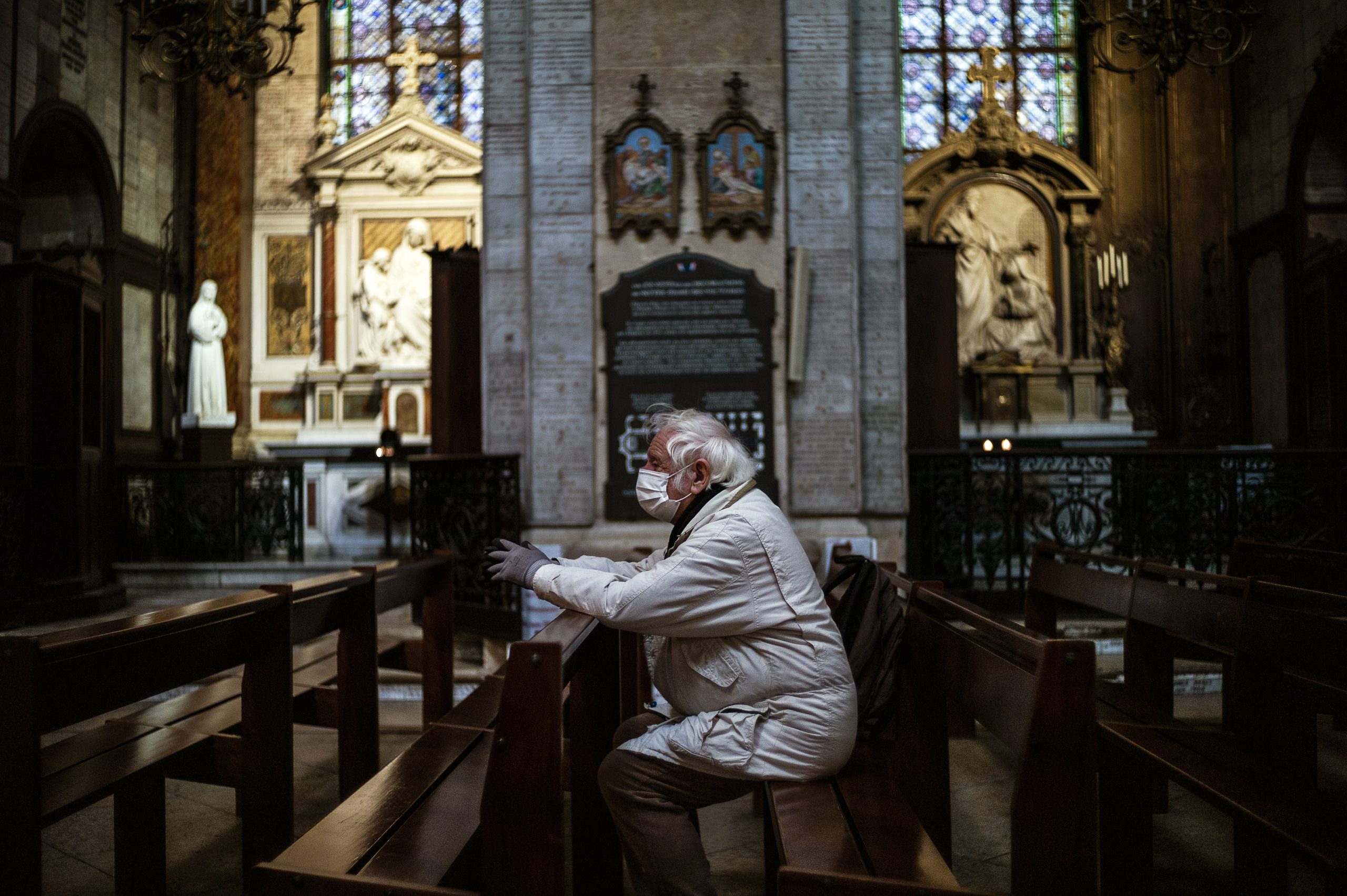 epa08325054 A man wearing a protective face mask prays inside Notre Dame des Victoires basilica in Paris, France, 26 March 2020. France is under lockdown in an attempt to stop the widespread of the SARS-CoV-2 coronavirus causing the Covid-19 disease.  EPA/YOAN VALAT