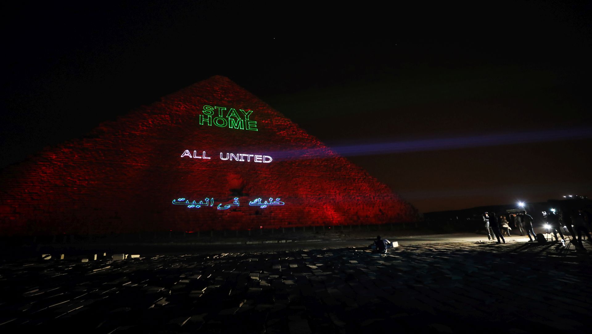 epa08332950 General view of the pyramids lit up with text encouraging Egyptians to stay home and safe because of COVID-19 and sending a thank you massage to those keeping poeple safe in Giza, Egypt, 30 March 2020. Egyptian authorities had announce a two-week curfew, which started on 25 March, during which public transportation will be suspended to avoid the spread of the SARS-CoV-2 coronavirus which causes the COVID-19 disease  EPA/KHALED ELFIQI