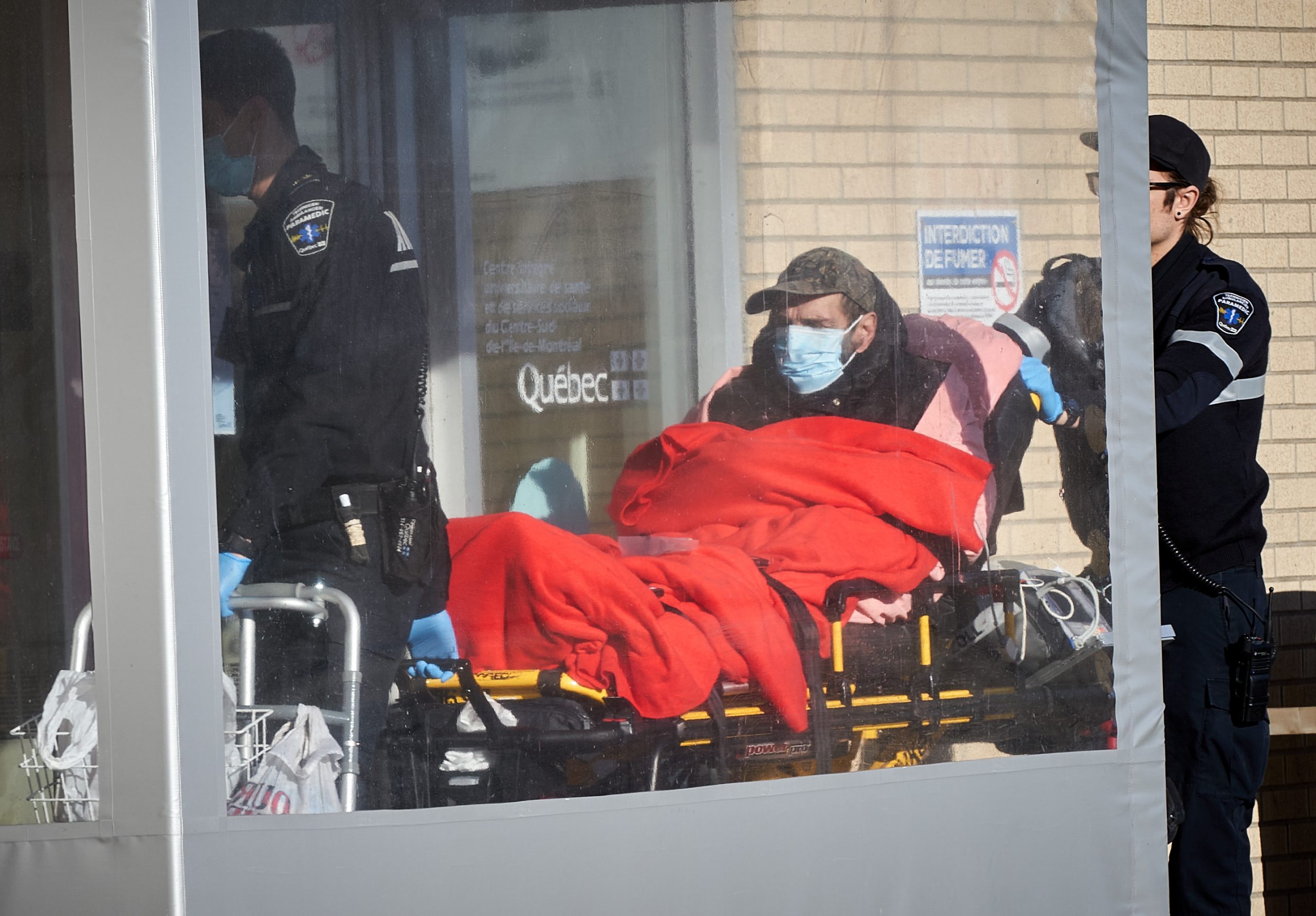 epa08296595 A paramedic brings a patient to Notre-Dame hospital in Montreal, Canada, 15 March 2020. There are more than 39 people with Coronavirus in Quebec after 18 new cases were confirmed on 15 March. The Quebec government announced today the closure of all bars, theatres, gyms, ski hills, sugar shacks, arcades and pools to slow the spread of the pandemic of coronavirus.  EPA/Andre Pichette