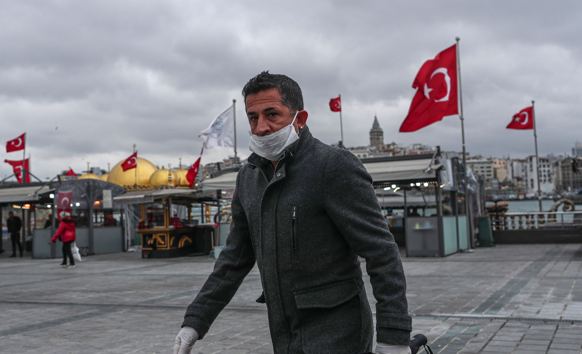 epa08321968 A man with a face mask and gloves walks in empty streets in Istanbul, Turkey, 25 March 2020. Turkish Health Minister Koca said on 24 March that there are 1,872 confirmed cases of the coronavirus and 44  related deaths from COVID-19. Turkey decided to halt public events, temporarily shut down schools and suspend sporting events in an attempt to prevent further spreading of the coronavirus.  EPA/SEDAT SUNA