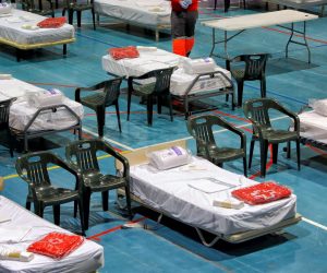 epa08337396 A member of the Spanish Red Cross sets up beds in a temporary hospital at Les Comas in Igualada, Barcelona, Spain, 01 April 2020. Countries around the world are taking increased measures to stem the widespread of the SARS-CoV-2 coronavirus which causes the COVID-19 disease.  EPA/Susanna Saez