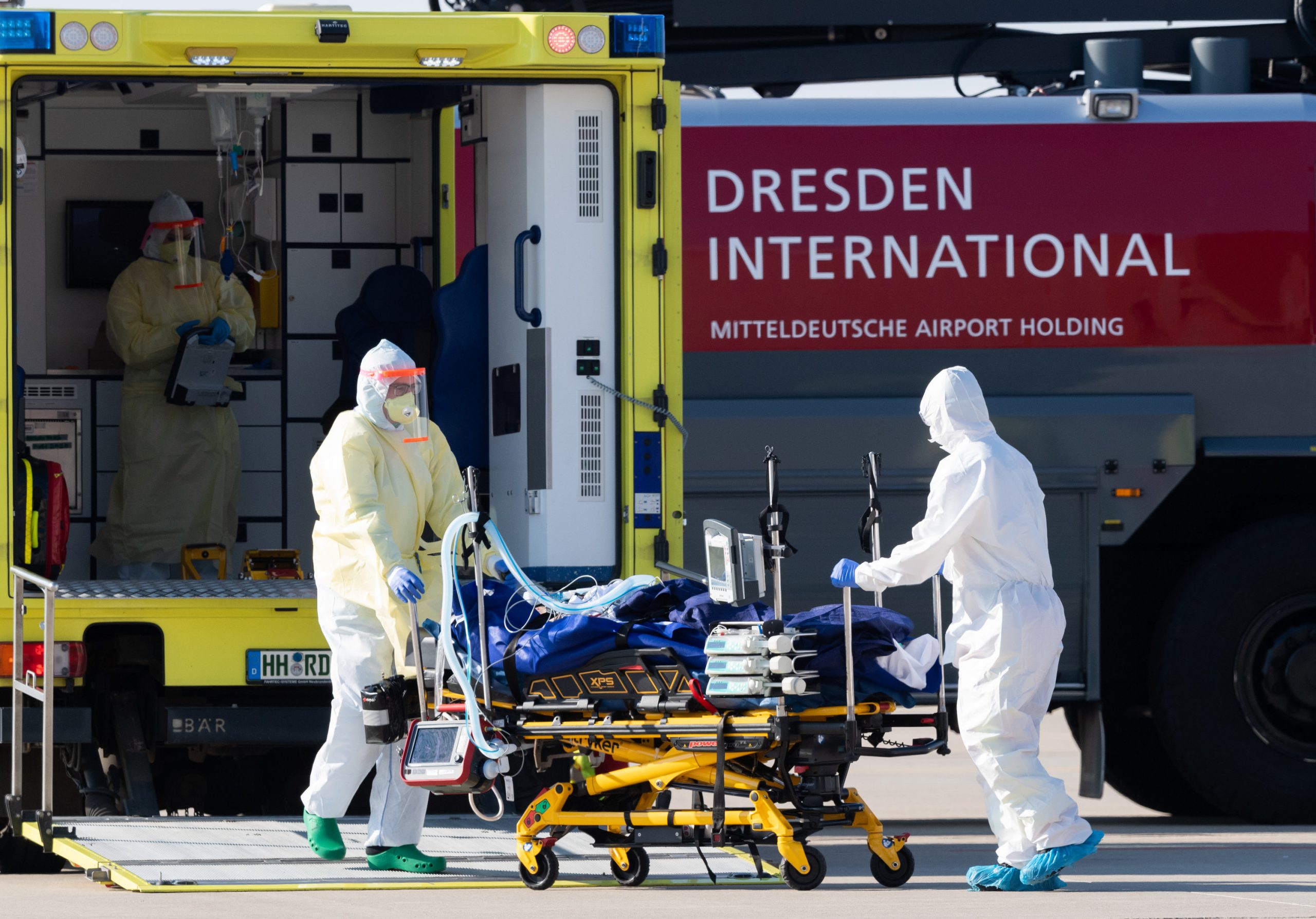02 April 2020, Saxony, Dresden: A medical team transport a French coronavirus patient from the Learjet 45 ambulance plane to the ambulance at Dresden International Airport, to be treated at Dresden University Hospital. Photo: Robert Michael/dpa-Zentralbild/dpa