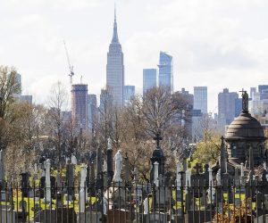 epa08354181 Gravestones and mausoleums in Calvary Cemetery in Queens are seen with the Empire State Building in the background in New York, New York, USA, on 09 April 2020. The number of patients being admitted to hospitals with COVID-19 in New York City, which is still considered to be the epicenter of the coronavirus outbreak in the United States, grew by the smallest amount in weeks but 799 people died between Wednesday and Thursday, which was another single day high for deaths.  EPA/JUSTIN LANE