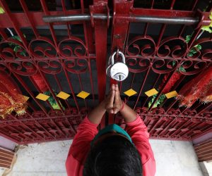 epa08355074 A Hindu devotee offers prayers from outside a locked temple during the lockdown at McLeod Ganj near Dharamshala, India, 10 April 2020. Indian Prime Minister Narendra Modi has declared a nationwide 21-day lockdown across India that started on 24 March 2020 to stem the widespread of the SARS-CoV-2 coronavirus which causes the COVID-19 disease.  EPA/SANJAY BAID