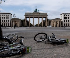 epa08364337 A view of fallen rental bicycles near the Brandenburg Gate in the empty Pariser Platz in Berlin, Germany, 15 April 2020. The popular tourist attraction site stands almost empty from visitors these days. The German government and local authorities are heightening measures to stem the spread of the coronavirus SARS-CoV-2 which causes the COVID-19 disease. The so called 'social distancing' restrictions should remain in effect until 19 April.  EPA/FILIP SINGER