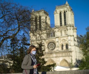 epa08365088 A woman wearing a protective face mask walks in front of the Notre-Dame cathedral on the first anniversary of the Notre-Dame fire in Paris, France, 15 April 2020. A year ago, on 15 April 2019, the 850-year-old Notre-Dame Cathedral of Paris suffered a devastating fire. Some 500 firefighters managed to prevent the entire cathedral from being reduced to ashes, although its celebrated spire has been destroyed. No major event were organized as France is under lockdown in an attempt to stop the widespread of the SARS-CoV-2 coronavirus causing the COVID-19 disease.  EPA/YOAN VALAT
