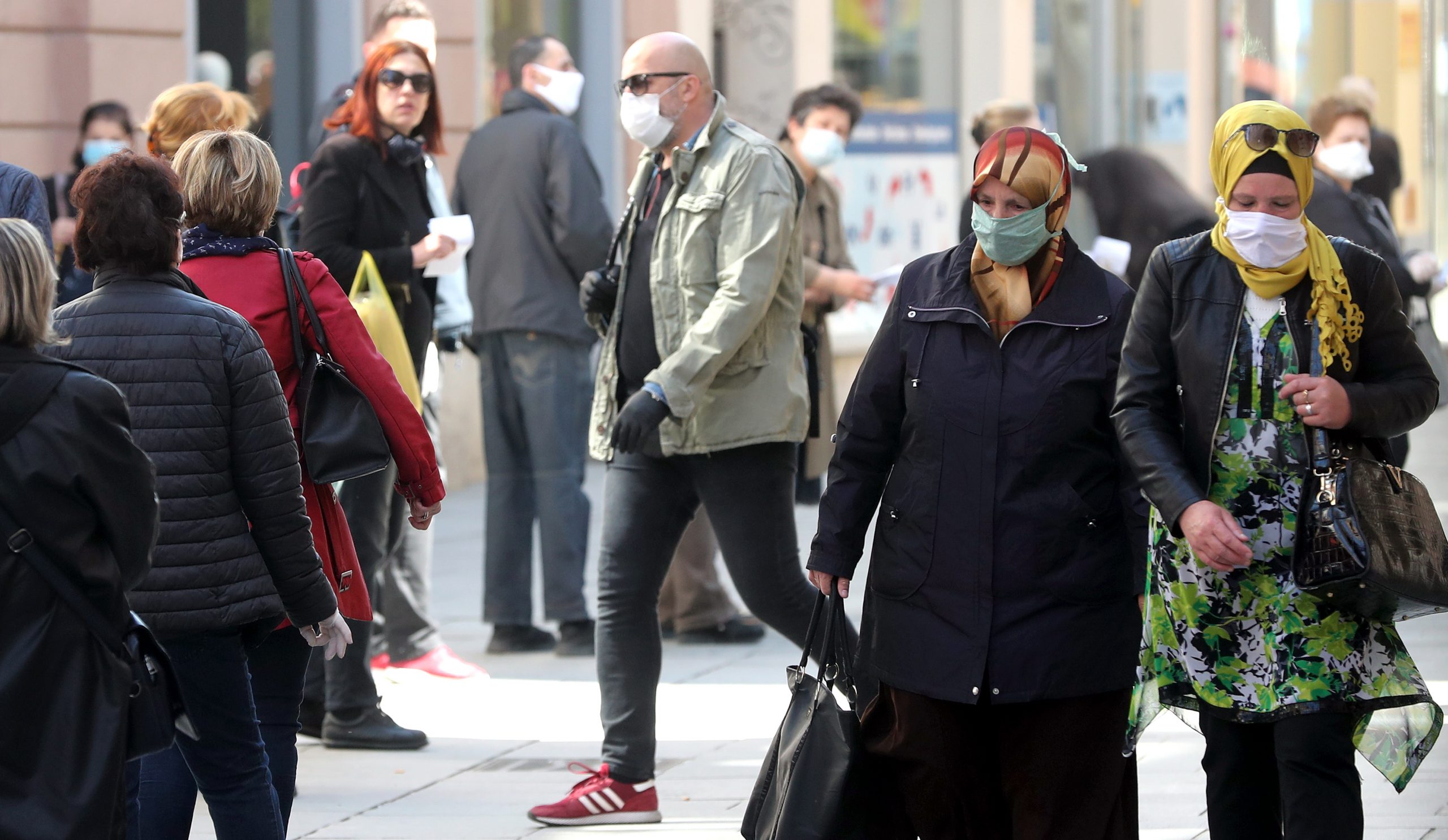 epa08366435 Bosnian people walk with face masks on a street following the outbreak of coronavirus, in Sarajevo, Bosnia and Herzegovina, 16 April 2020. Countries around the world are taking increased measures to stem the widespread of the SARS-CoV-2 coronavirus which causes the COVID-19 disease.  EPA/FEHIM DEMIR