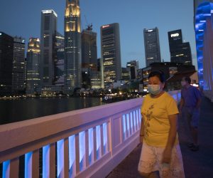 epa08370314 People wearing masks walk in the Central Business District in Singapore, 17 April 2020 (issued 18 April 2020), during the coronavirus disease (COVID-19) pandemic. Singapore on 18 April is on its 12th day into a month-long 'circuit breaker' period where non-essential services workplaces and schools are closed among measures to prevent the spread of the COVID-19 infectious disease.  EPA/HOW HWEE YOUNG