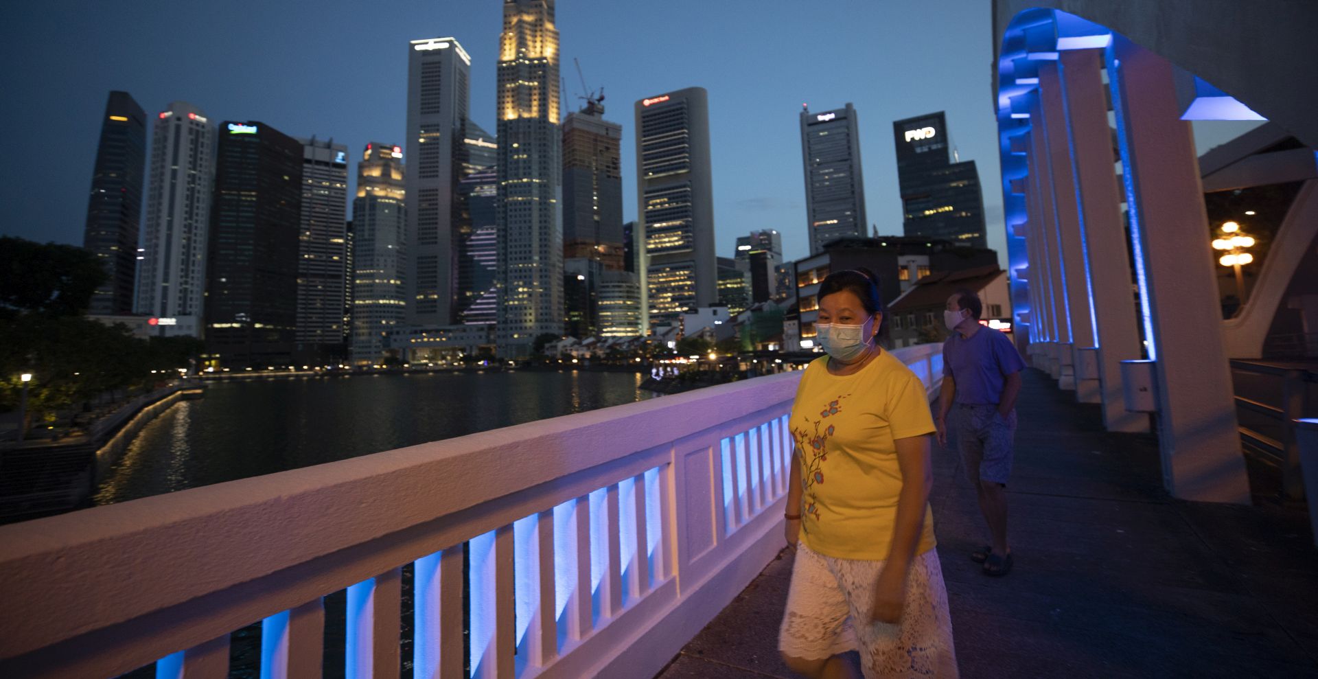 epa08370314 People wearing masks walk in the Central Business District in Singapore, 17 April 2020 (issued 18 April 2020), during the coronavirus disease (COVID-19) pandemic. Singapore on 18 April is on its 12th day into a month-long 'circuit breaker' period where non-essential services workplaces and schools are closed among measures to prevent the spread of the COVID-19 infectious disease.  EPA/HOW HWEE YOUNG
