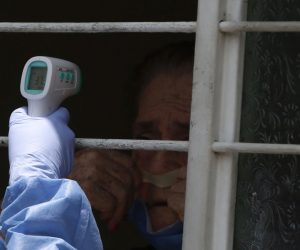 epaselect epa08374222 A health worker measures the temperature of a woman as part of a campaign against the coronavirus disease, in Cali, Colombia, 20 April 2020. Cali's Secretariat of Health has identified in the city eighth zones with high risk of contagion with the SARS-CoV-2 coronavirus which causes the Covid-19 disease, and is performing campaigns to early detect the sources of coronavirus.  EPA/ERNESTO GUZMAN JR