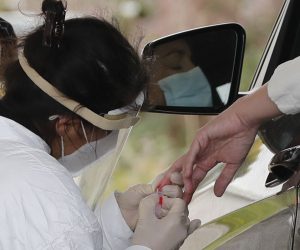 epa08374320 A health care worker takes a blood sample for an antibody testing by a finger-prick from a person before doing a nasal swab diagnostic COVID-19 test at a drive through at Mesa Park in the town of Bolinas, California, USA, 20 April 2020. The new project, a privately-funded guerrilla-style operation lead by Venture capitalist Jyri Engestrom of Finland and resident of Bolinas, and Cyrus Harmon, founder of the startup Olema Pharmaceuticals, and resident, partnered with UCSF scientists to test the whole reclusive town of 1,600 residents.  EPA/JOHN G. MABANGLO