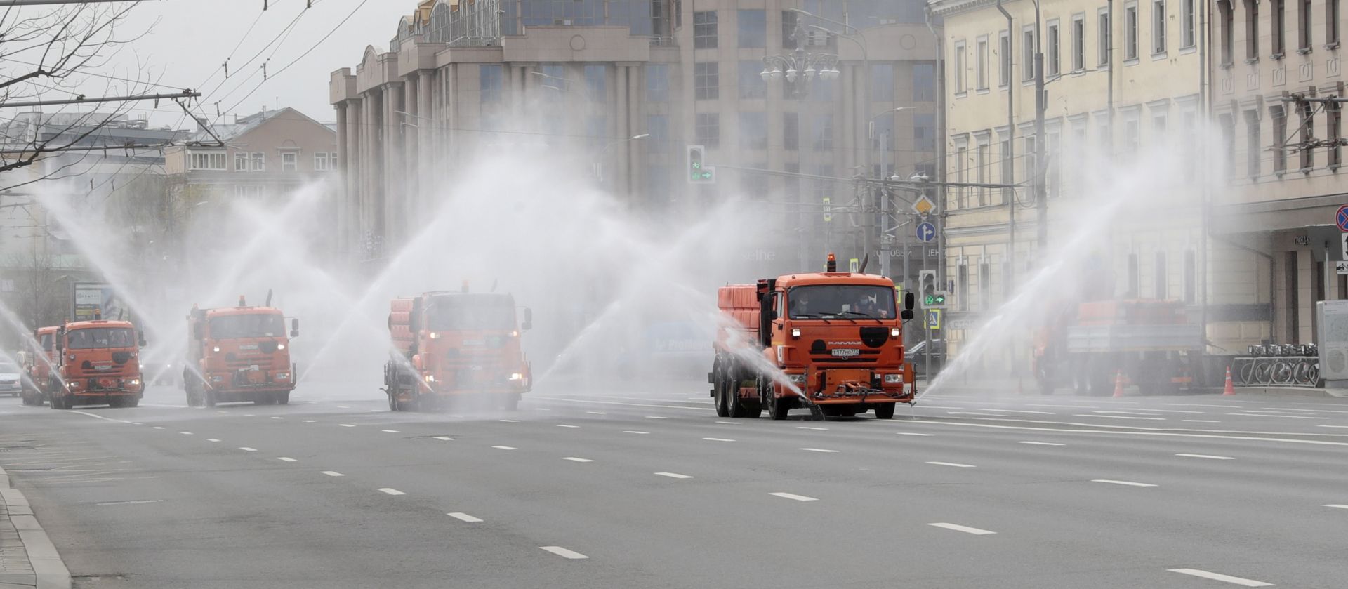 epa08382158 Municipal watering trucks spray disinfectant liquid on an avenue in downtown Moscow, Russia, 24 April 2020. This is the fifth mass disinfection of public spaces undertaken in Moscow so far in a bid to curb the spread of the pandemic COVID-19 disease caused by the SARS-CoV-2 coronavirus.  EPA/SERGEI CHIRIKOV