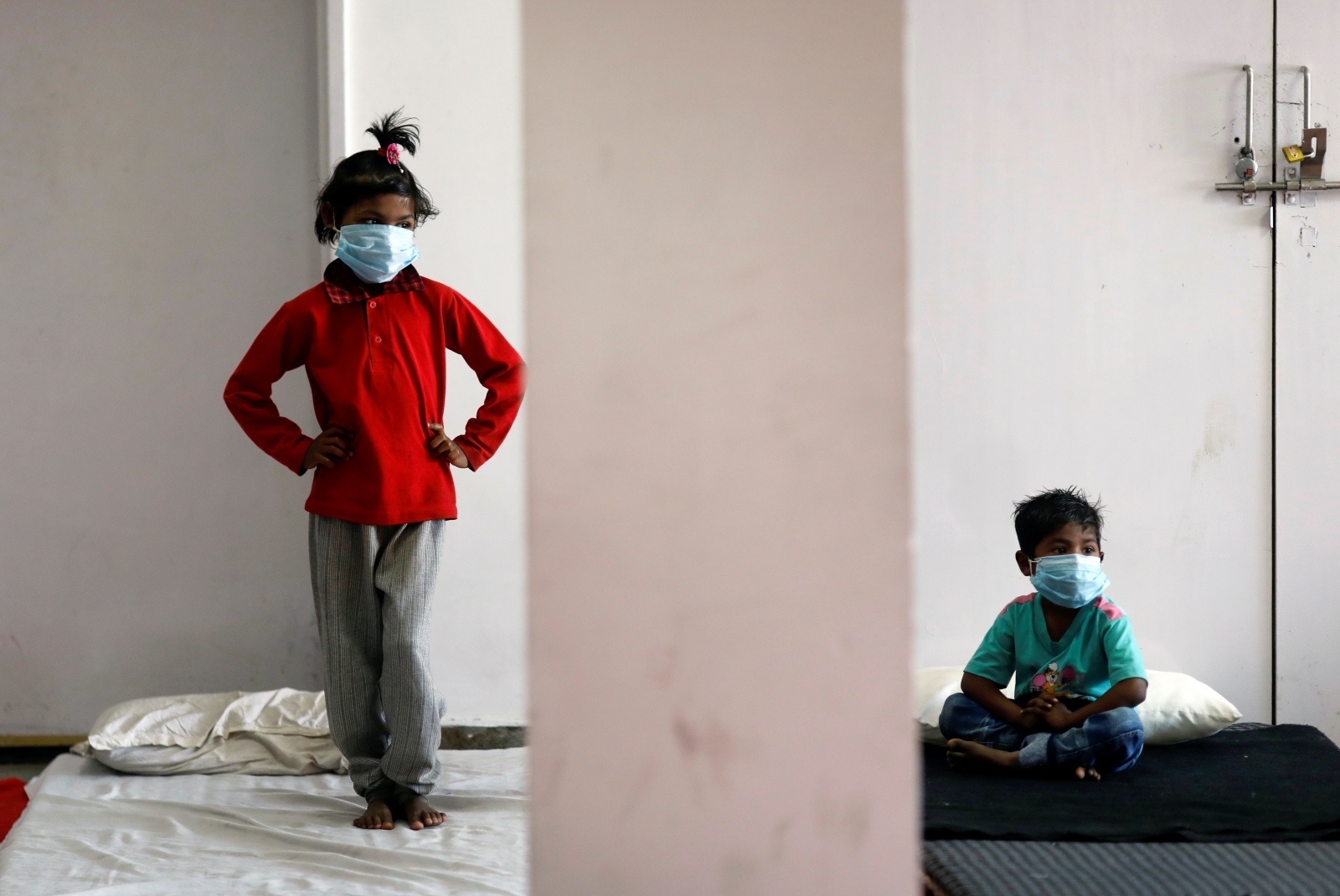 Lockdown to slow the spread of the coronavirus disease (COVID-19), in New Delhi Children of migrant workers wear protective masks inside a sports complex turned into a shelter, during a 21-day nationwide lockdown to slow the spread of the coronavirus disease (COVID-19), in New Delhi, India, April 4, 2020. REUTERS/Adnan Abidi ADNAN ABIDI