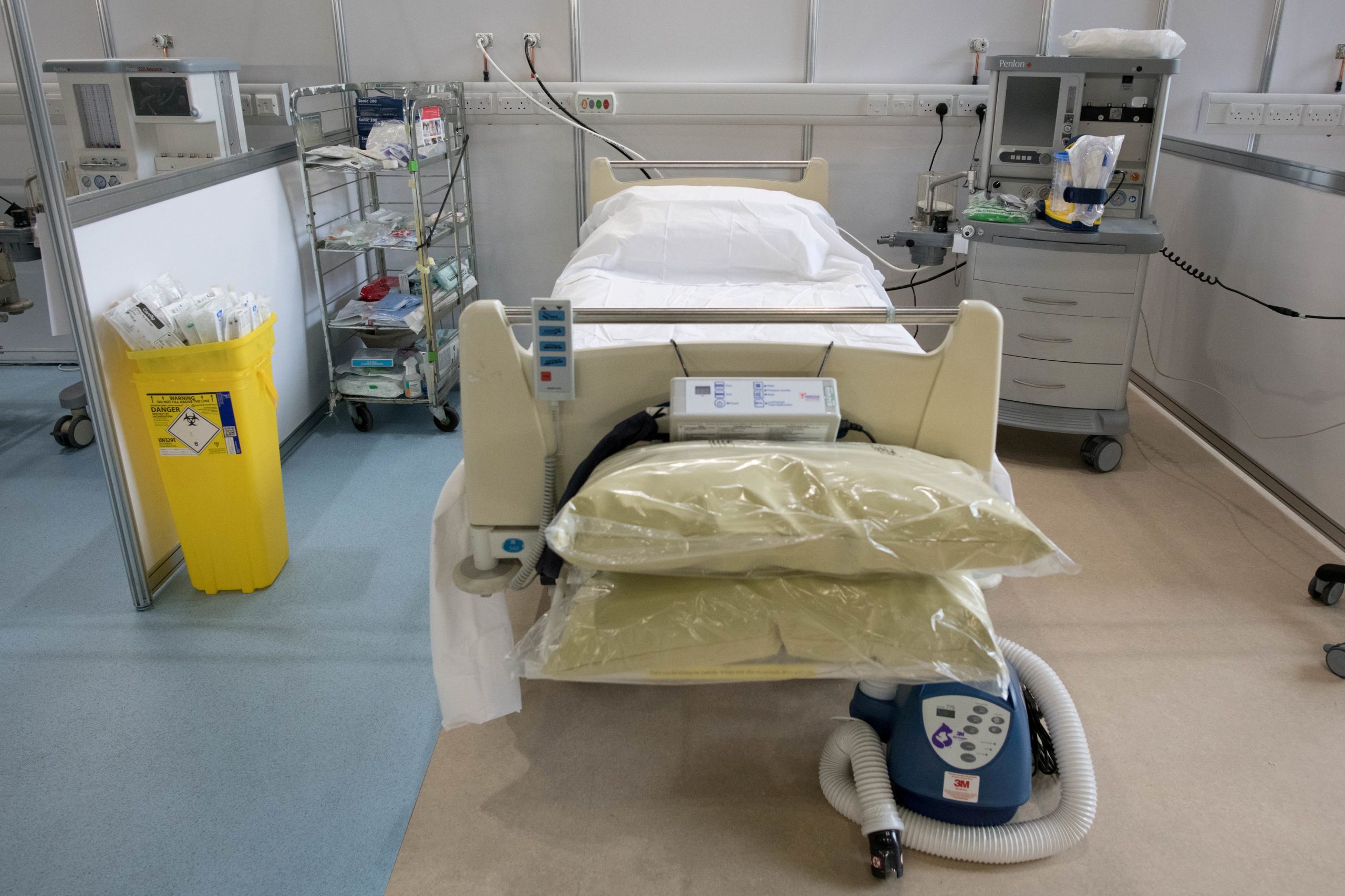 FILE PHOTO: Britain builds NHS Nightingale Hospital for coronavirus patients in London FILE PHOTO: A hospital bed and respirator at ExCel London, seen inside during its conversion into the temporary NHS Nightingale Hospital, comprising of two wards, each of 2,000 people, to help tackle the coronavirus outbreak, in Newham, London, Britain March 30, 2020. To match Special Report HEALTH-CORONAVIRUS/BRITAIN-PATH   Stefan Rousseau/Pool via REUTERS/File Photo POOL New