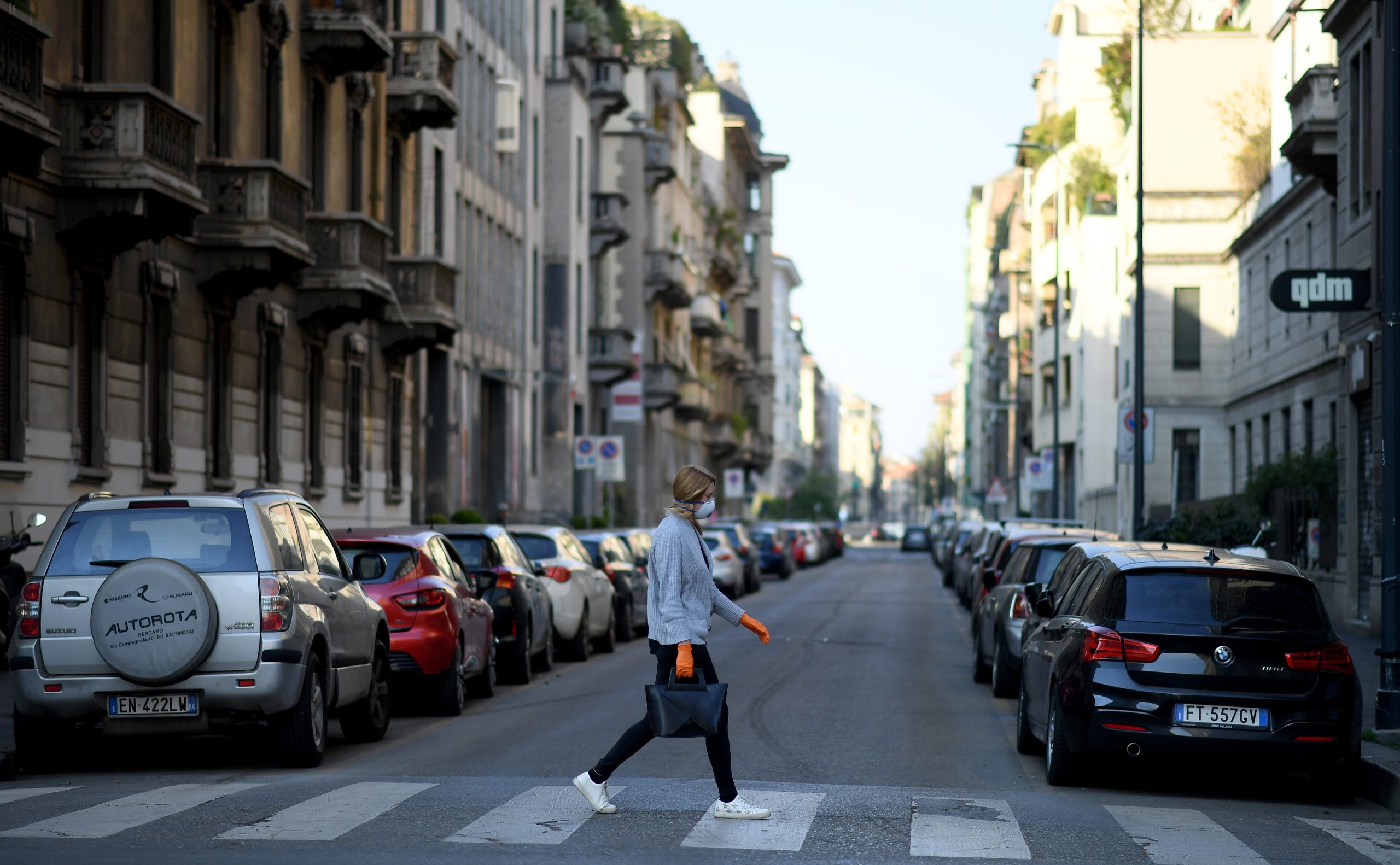 The outbreak of the coronavirus disease (COVID-19) in Milan A woman wearing a protective face mask crosses a street, amid the coronavirus disease (COVID-19) outbreak in Milan, Italy April 9, 2020. REUTERS/Daniele Mascolo DANIELE MASCOLO