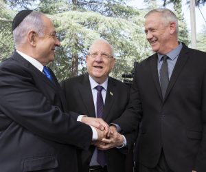 epa08373681 (FILE) -  Israeli Prime Minister Benjamin Netanyahu (L), Israeli President Reuven Rivlin (C) and Benny Gantz, former Israeli Army Chief of Staff and chairman of the Blue and White Israeli centrist political alliance (R) join hands as they attend a memorial service for late Israeli president Shimon Peres at Mount Herzl in Jerusalem, 19 September 2019(issued 04 April 2020). Media report that Netanyahu  and Gantz agreed to sign a coalition deal to form a government after three elections and to rotate the premiership.  EPA/ABIR SULTAN