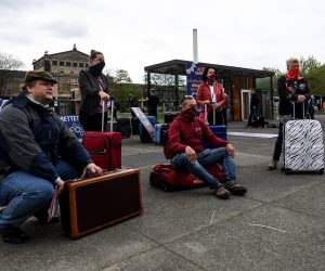 epa08391015 Protesters sit on luggage during a demonstration of travel agencies employees in Dresden, Germany, 29 April 2020. Some of Saxony's travel agencies workers blocked Dresden streets with tour buses to draw attention to the difficult economic situation of the tourism industry during the coronavirus pandemic.  EPA/FILIP SINGER