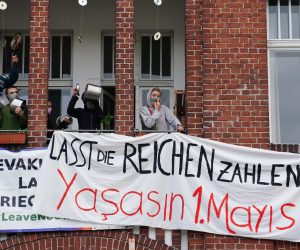 epa08393798 Demonstrators on a balcony wear protective masks holding banners reading 'Let the rich pay' during a protest in the Berlin district Wedding in Berlin, Germany, 30 April 2020. On the eve of the feast day of Saint Walpurga, in German tradition witches are believed to hold an annual meeting in a range of wooded hills in central Germany as they await the arrival of spring. In the late 19th century, May Day was chosen as the date for International Workers' Day with rallies and demonstrations up until now. This year, May Day takes place under the influence of the pandemic crisis of the SARS-CoV-2 coronavirus which causes the Covid-19 disease.  EPA/CLEMENS BILAN