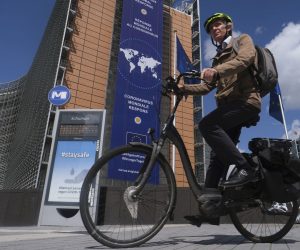 epa08393512 A cyclist passes in front of a new banner about the coronavirus global response in front of the European Commission headquarters in Brussels, Belgium, 30 April 2020. In order to contain the spread of COVID-19, Belgium is implementing confinement guidelines for the public which is scheduled to be in place until 04 May  2020. Only supermarkets and essential trade will remain open.  EPA/OLIVIER HOSLET