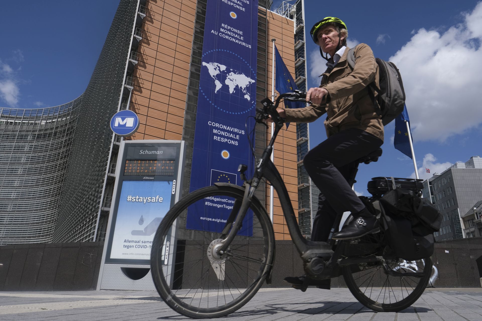 epa08393512 A cyclist passes in front of a new banner about the coronavirus global response in front of the European Commission headquarters in Brussels, Belgium, 30 April 2020. In order to contain the spread of COVID-19, Belgium is implementing confinement guidelines for the public which is scheduled to be in place until 04 May  2020. Only supermarkets and essential trade will remain open.  EPA/OLIVIER HOSLET