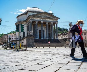 epa08398756 A woman wearing a protective face mask walks in front of the church of Gran Madre di Dio in Turin, Italy, 03 May 2020, amid the ongoing coronavirus COVID-19 pandemic. Countries around the world are taking measures to stem the widespread of the SARS-CoV-2 coronavirus which causes the COVID-19 disease.  EPA/TINO ROMANO