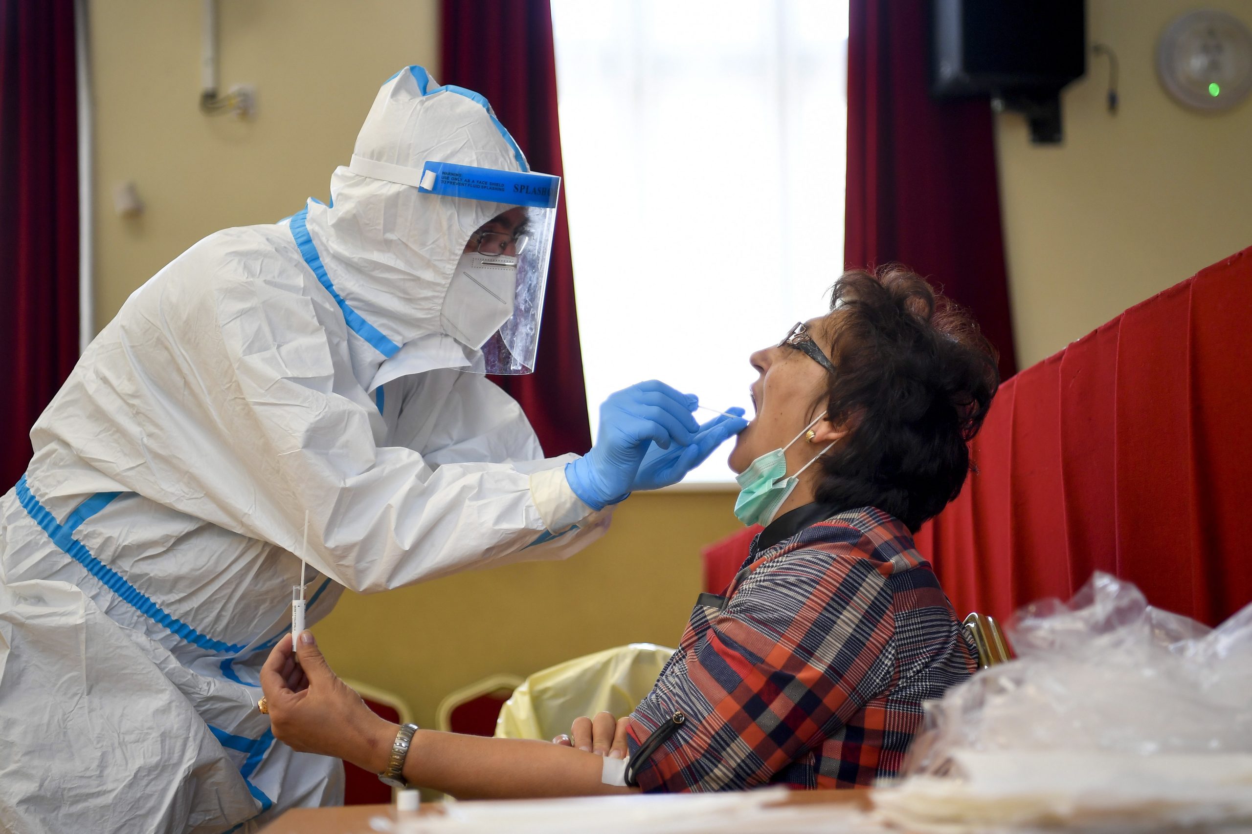 epa08400781 A medical professional wearing a protective suit takes a sample for a coronavirus test at a temporary testing station operated by the University of Debrecen Clinical Center in Berettyoujfalu, Hungary, 04 May, 2020. Four Hungarian medical training schools have begun the screening of some 18 thousand people as a representative statistical sample to get exact figures concerning the spread of the coronavirus in Hungary.  EPA/Zsolt Czegledi HUNGARY OUT