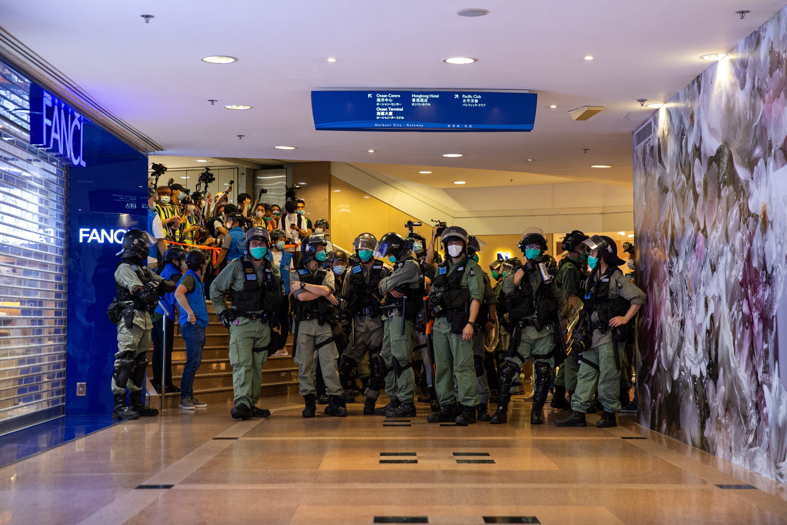 epa08413030 Police officers clear a shopping mall of protesters during a 'sing with you' protest at a shopping mall in Hong Kong, China, 10 May 2020. A heavy police presence in Tsim Sha Tsui thwarted plans for a pro-independence march, but several 'sing with you' protests popped up at several malls across Hong Kong.  EPA/JEROME FAVRE