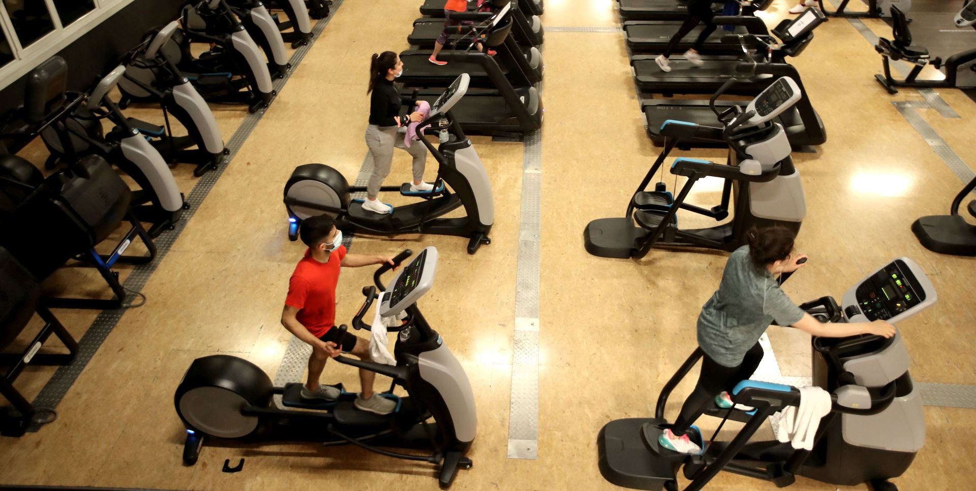 epa08413649 Customers exercise at the McFIT gym in Cologne, Germany, 10 May 2020. Due to the gradual relaxation of the lockdown restrictions imposed in a bid to slow down the spread of the pandemic COVID-19 disease caused by the SARS-CoV-2 coronavirus, gyms in North Rhine-Westphalia have started reopening, though with extra hygiene precautions.  EPA/FRIEDEMANN VOGEL
