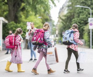 epa08413923 Schoolgirls walk on the first day of school after the public shutdown because of the coronavirus pandemic, at the Hutten schoolhouse in Zurich, Switzerland, 11 May 2020. Switzerland is one of the countries introducing partial easing of lockdowns.  EPA/ENNIO LEANZA