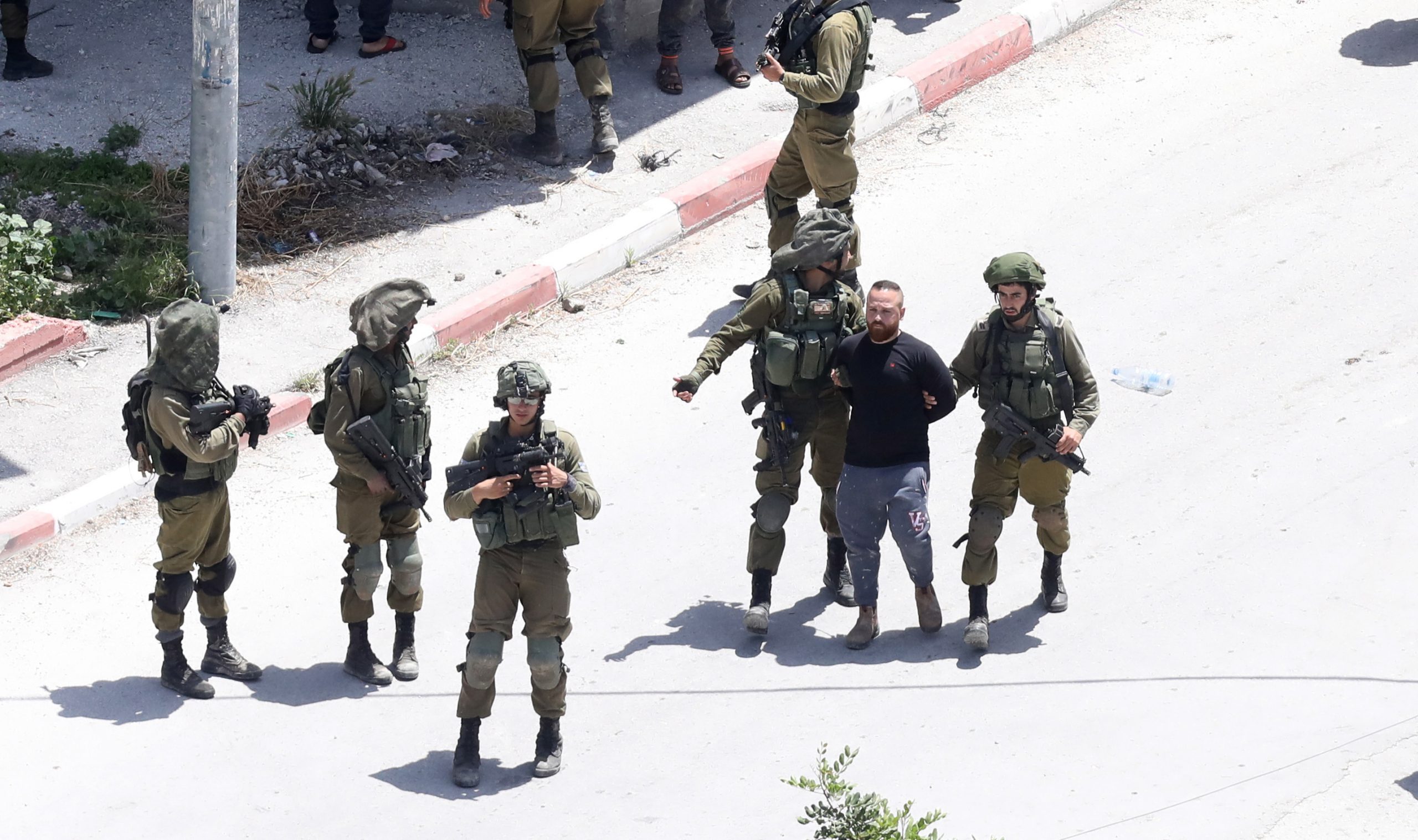 epa08416720 Israeli soldiers arrest a Palestinian during an Israeli army operation in the village of Yabad, near the West Bank City of Jenin, 12 May 2020. A soldier was killed on 12 May when a rock was dropped on his head during an operation in the West Bank, according to an Israeli military statement.  EPA/ALAA BADARNEH