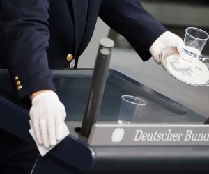 epa08423458 An usher cleans the speaker's desk in between speeches during a session of the German parliament 'Bundestag' in Berlin, Germany, 15 May 2020. The German parliament will discuss the global humanitarian situation amid the coronavirus crisis, among other topics.  EPA/CLEMENS BILAN