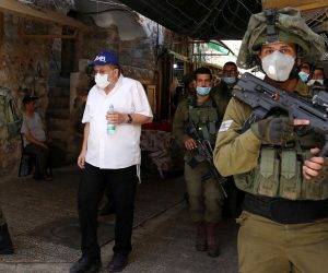 epa08425425 Israeli soldiers and a group of Jewish settlers in protective masks during a weekly guided tour in the old city of Hebron, amid the ongoing coronavirus Covid-19 pandemic in the West Bank, 16 May 2020. Every Saturday a tour through Hebron's Old City, which is usually off limits for Israeli settlers, is organized by Israeli settlers and guests in Hebron. Palestians oppose those tours during which a guide explains about the alleged 'Jewish history' of the city also claiming that the Old City of Hebron is a Jewish property. Hebron is a divided city with several hundred Jewish settlers living among over 140,000 Palestinians.  EPA/ABED AL HASHLAMOUN