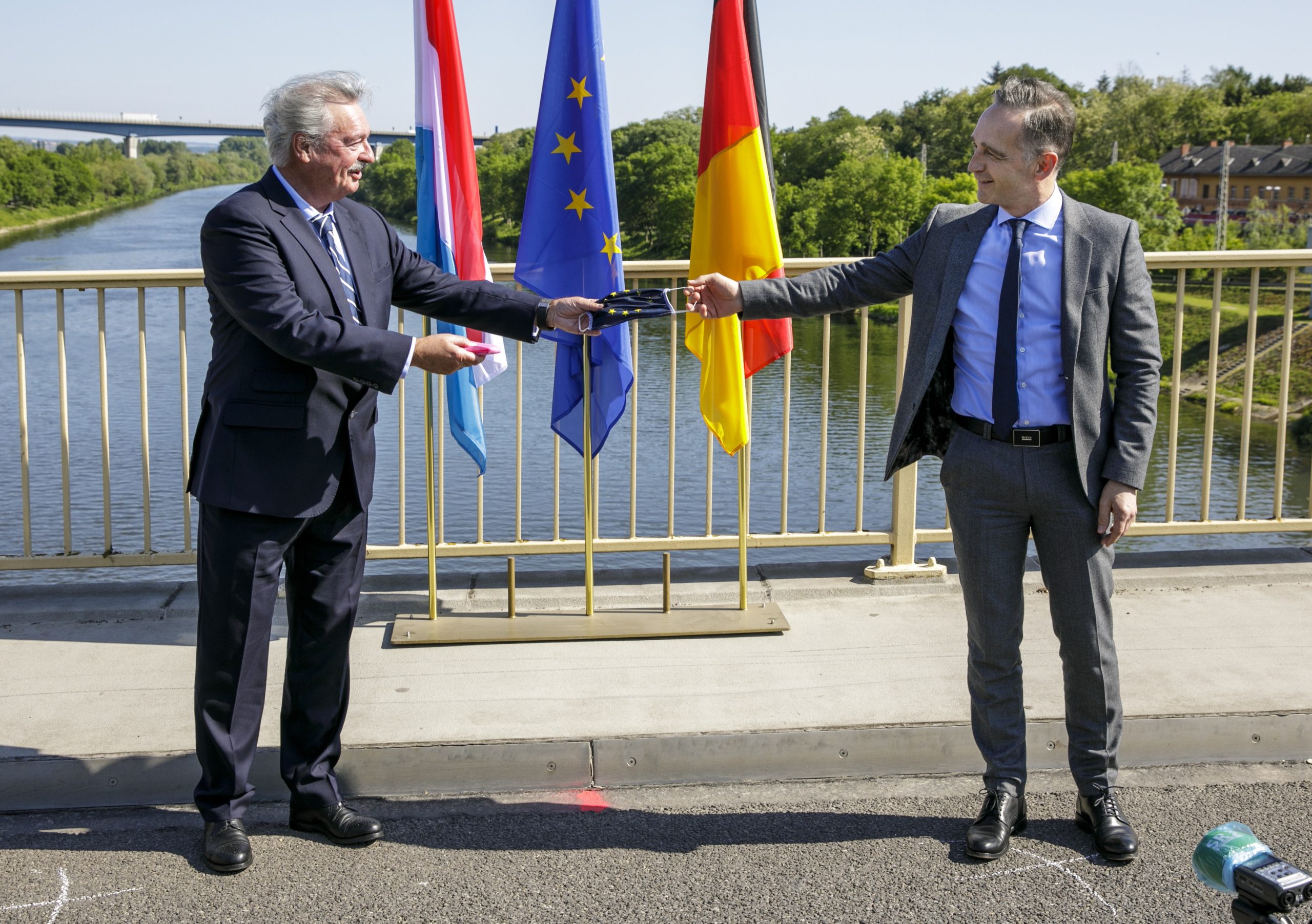 epa08425300 Germany's Foreign Affairs Minister Heiko Maas (R) and Luxembourg's Foreign Affairs Minister Jean Asselborn (L) meet on a bridge over the Moselle River between the cities of Perl and Schengen, Luxembourg, 16 May 2020, on the day of the reopening of their common border after a gradual lifting of controls introduced in March to curb the spread of the coronavirus disease (COVID-19) pandemic.  EPA/THOMAS IMO / POOL