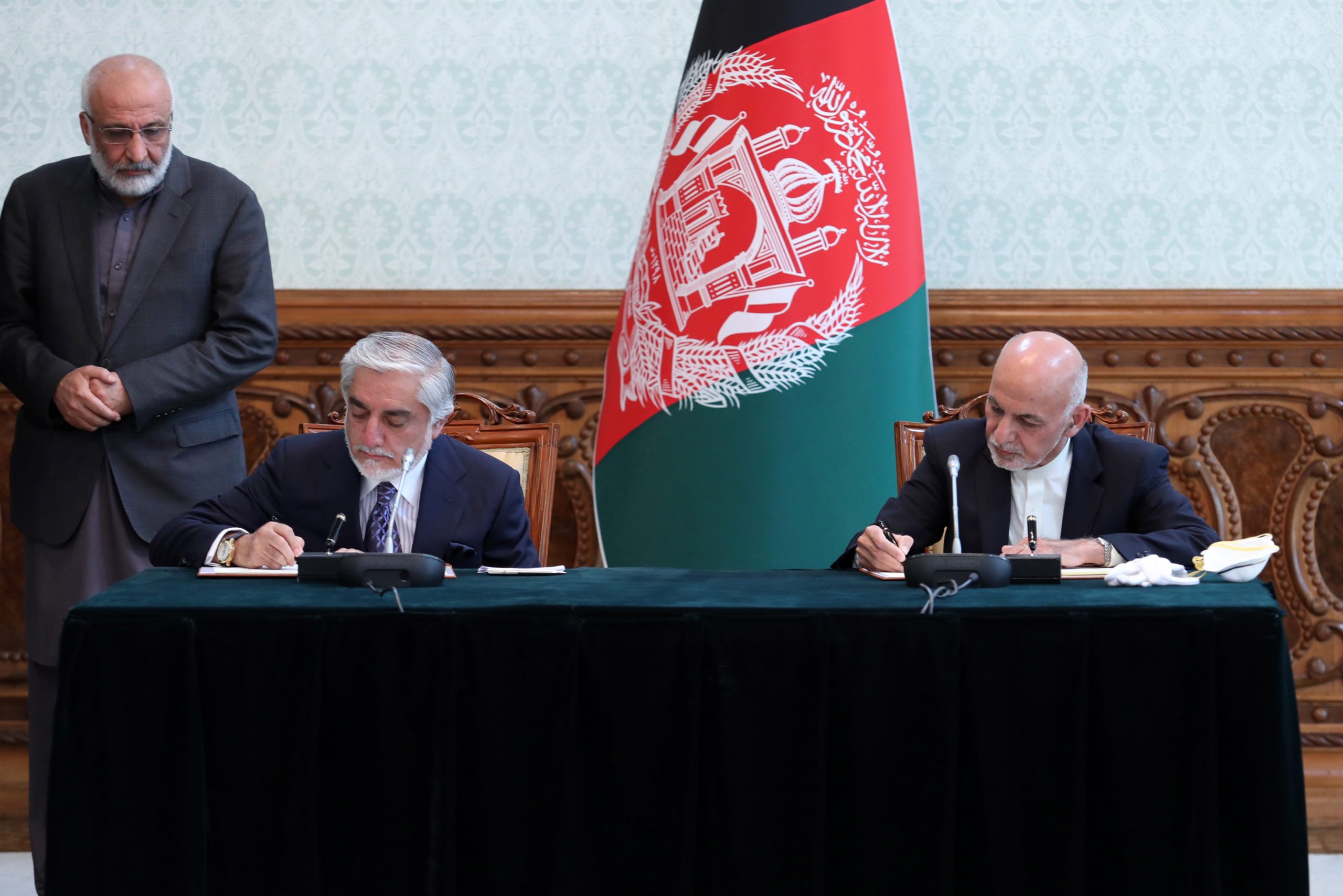 epa08428018 A handout photo made available by the Afghan President's office shows Afghanistan's President Ashraf Ghani (seated, R) and Abdullah Abdullah (seated, L), the second most voted in the September 2019's elections, signing an agreement during a meeting in Kabul, Afghanistan, 17 May 2020. President Ghazni and Abdullah Abdullah reached an agreement to end months of stalemate over the outcome of the vote. According to the agreemet Dr. Abdullah will lead the National Reconciliation High Council and members of his team will be included in the cabinet.  EPA/PRESIDENTIAL PALACE / HANDOUT HANDOUT  HANDOUT EDITORIAL USE ONLY/NO SALES