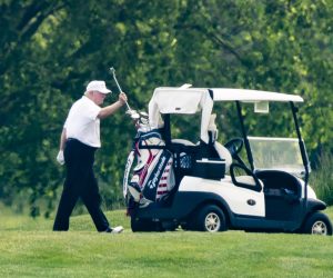 epa08440052 US President Donald J. Trump, wearing a white hat and white Polo shirt, plays golf at the Trump National Golf Club in Sterling, Virginia, USA, 23 May 2020. It is the first time the president has played golf since the lockdown over the coronavirus COVID-19 pandemic.  EPA/JIM LO SCALZO