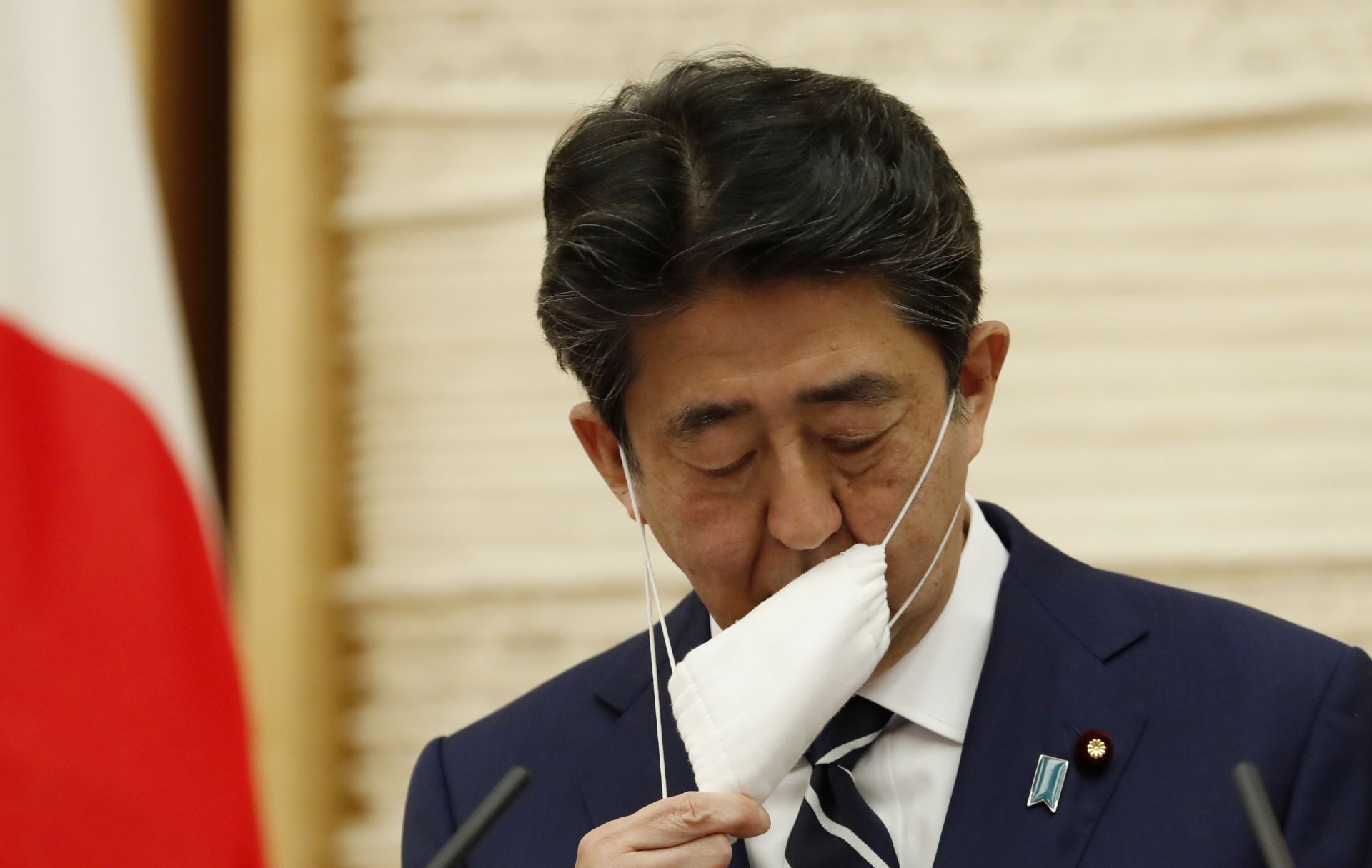 epa08442569 Japan's Prime Minister Shinzo Abe removes his mask as he arrives at a news conference in Tokyo, Japan, 25 May 2020. According to media reports, Abe lifted the state of emergency in the country after a dramatic drop in coronavirus cases.  EPA/KIM KYUNG-HOON / POOL