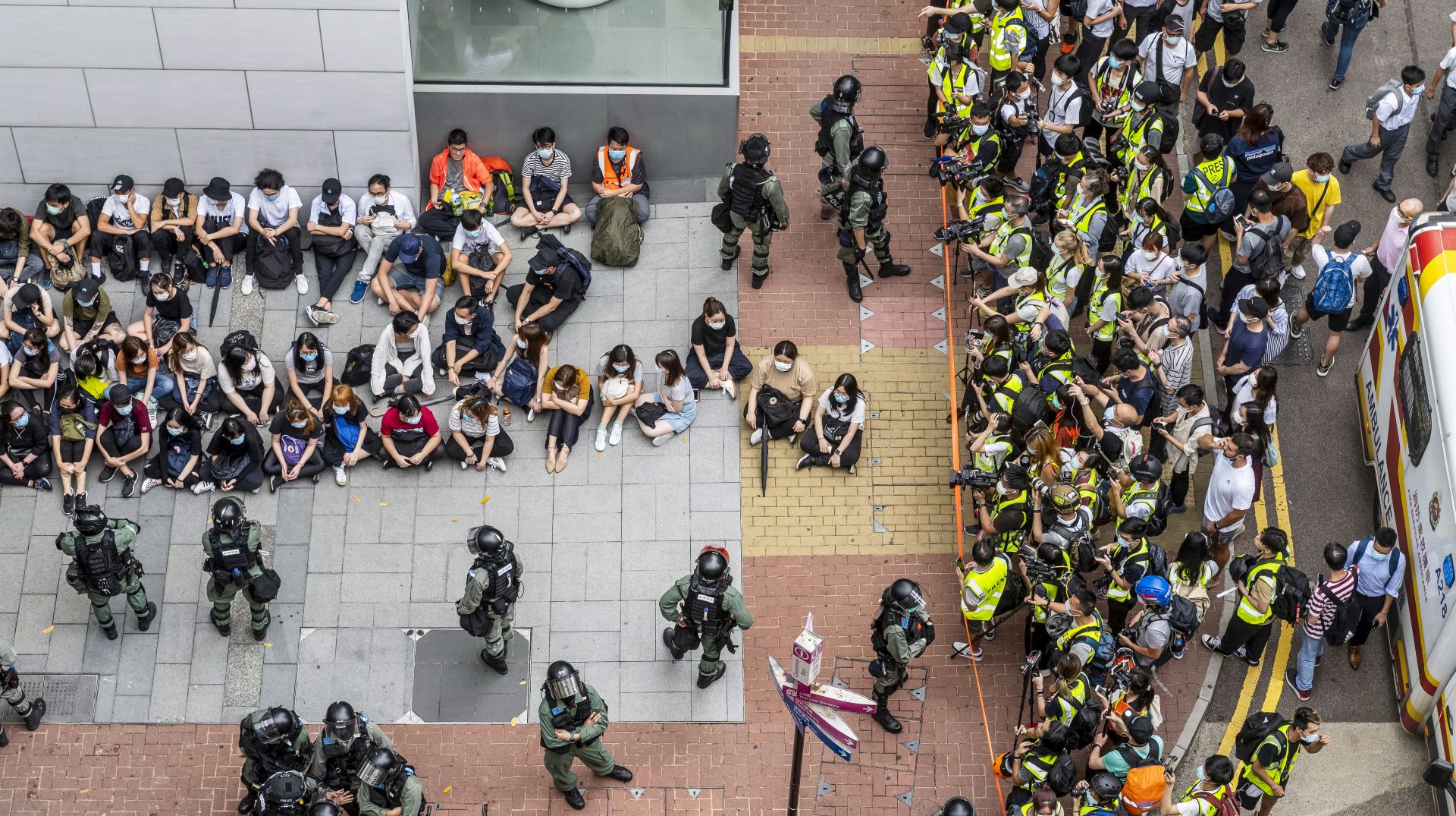 epaselect epa08446614 A large group of detainees are seen sitting on the ground as police has set up a police cordon around the area in Causeway Bay, Hong Kong, China, 27 May 2020. The Second Reading debate on the National Anthem Bill is set to resume at the Legislative Council on 27 May amid growing anger at Beijing's plan to impose a national security law on the city banning sedition, secession and subversion through a method that could bypass Hong Kong's legislature.  EPA/MIGUEL CANDELA