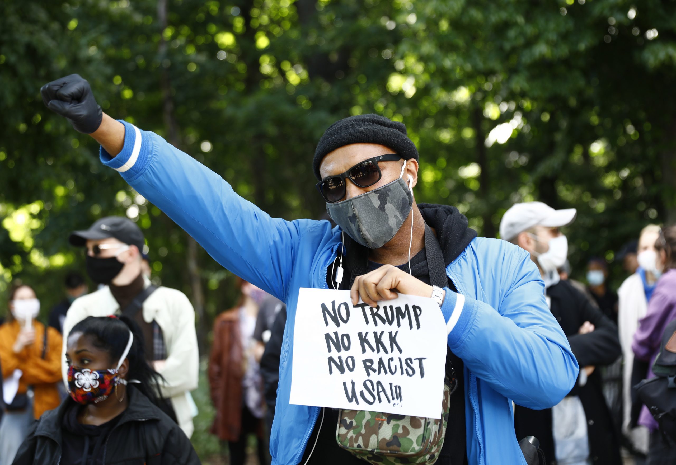 epaselect epa08454476 A Protester of the Afroamerican Black lives matters with a placard 'No Trump, No KKK, No Racist USA!!!' takes part in a demonstration against the Police brutality in USA in memory of George Floyd in front of the US embassy in Berlin, Germany, 30 May 2020. A bystander's video posted online on 25 May, appeared to show George Floyd, 46, pleading with arresting officers that he couldn't breathe as an officer knelt on his neck in Minneapolis, Minnesota. The unarmed black man later died in police custody.  A series of demonstrations throughout the German capital, calling for ending of the social and economical restrictions imposed due to the coronavirus pandemic. The events are organised by groups of various motives, right wing activists, conspiracy theory believers and more, several counter demonstrations by left leaning organisations were also taking place.  EPA/MICHELE TANTUSSI