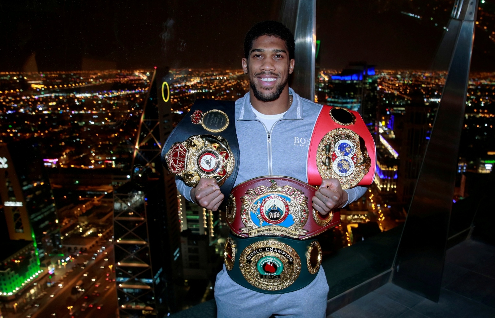 FILE PHOTO: Anthony Joshua poses with the IBF, WBA, WBO & IBO World Heavyweight belts after winning his title fight against Andy Ruiz Jr FILE PHOTO: Boxing - Anthony Joshua poses with the IBF, WBA, WBO & IBO World Heavyweight belts after winning his title fight against Andy Ruiz Jr - Al Faisaliah Tower, Riyadh, Saudi Arabia - December 8, 2019  Anthony Joshua poses with the belts  Action Images via Reuters/Andrew Couldridge/File Photo Andrew Couldridge
