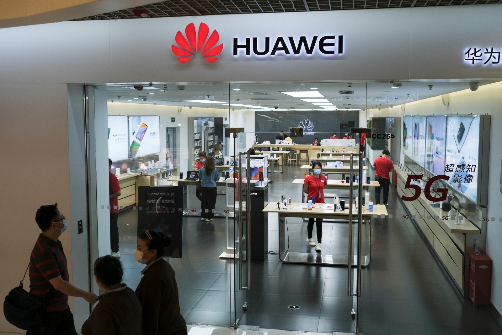 People wearing face masks walk past a?Huawei?store at a shopping mall, following an outbreak of the coronavirus disease (COVID-19), in Beijing People wearing face masks walk past a?Huawei?store at a shopping mall, following an outbreak of the coronavirus disease (COVID-19), in Beijing, China May 18, 2020. REUTERS/Carlos Garcia Rawlins CARLOS GARCIA RAWLINS