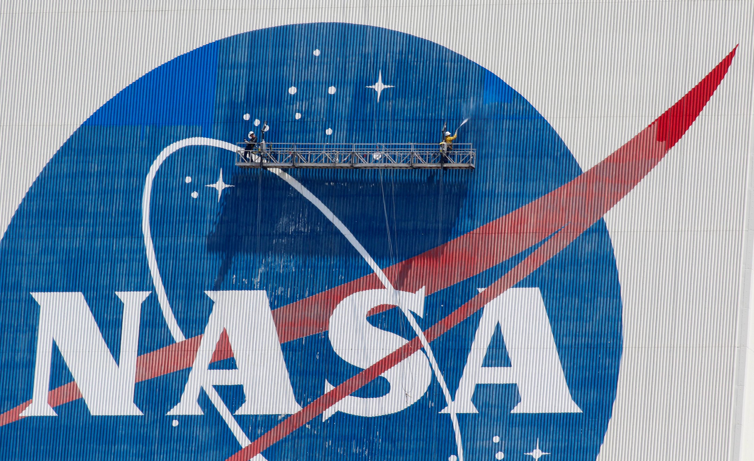 Workers pressure wash the logo of NASA on the Vehicle Assembly Building, in Cape Canaveral Workers pressure wash the logo of NASA on the Vehicle Assembly Building before SpaceX will send two NASA astronauts to the International Space Station aboard its Falcon 9 rocket, at the Kennedy Space Center in Cape Canaveral, Florida, U.S., May 19, 2020. REUTERS/Joe Skipper JOE SKIPPER
