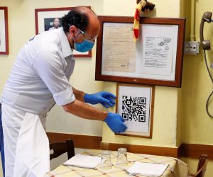 The coronavirus disease (COVID-19) outbreak in Rome A waiter places a placard showing a barcode that customers scan on their phones to view the restaurant menu, to avoid using paper menus that are touched by many customers, as Italy eases some of the lockdown measures put in place following the coronavirus disease (COVID-19) outbreak, in Rome, Italy, May 20, 2020. REUTERS/Guglielmo Mangiapane GUGLIELMO MANGIAPANE