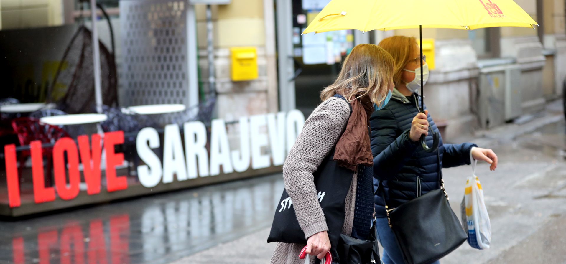 epa08444481 Two women walk past with an umbrella during a rainy day in Sarajevo, Bosnia and Herzegovina, 26 May 2020. Countries around the world are taking increased measures to stem the widespread of the SARS-CoV-2 coronavirus which causes the COVID-19 disease.  EPA/FEHIM DEMIR