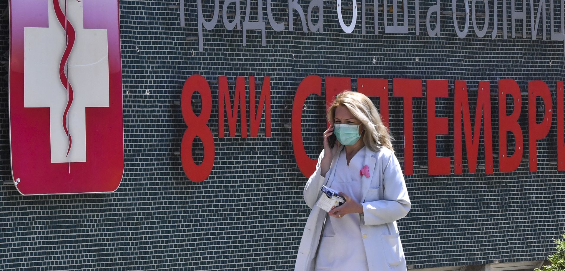 epa08462707 A medical staff in a protective mask walks outside of the city hospital 8-th September in Skopje, North Macedonia, 03 June 2020. A week ago the North Macedonian Government decided to drop the restrictive measures which were in place due to the coronavirus COVID-19 pandemic. According the official statistic in the last two days, North Macedonia have more newly infected people with COVID - 19 than all neighboring countries together.  EPA/GEORGI LICOVSKI