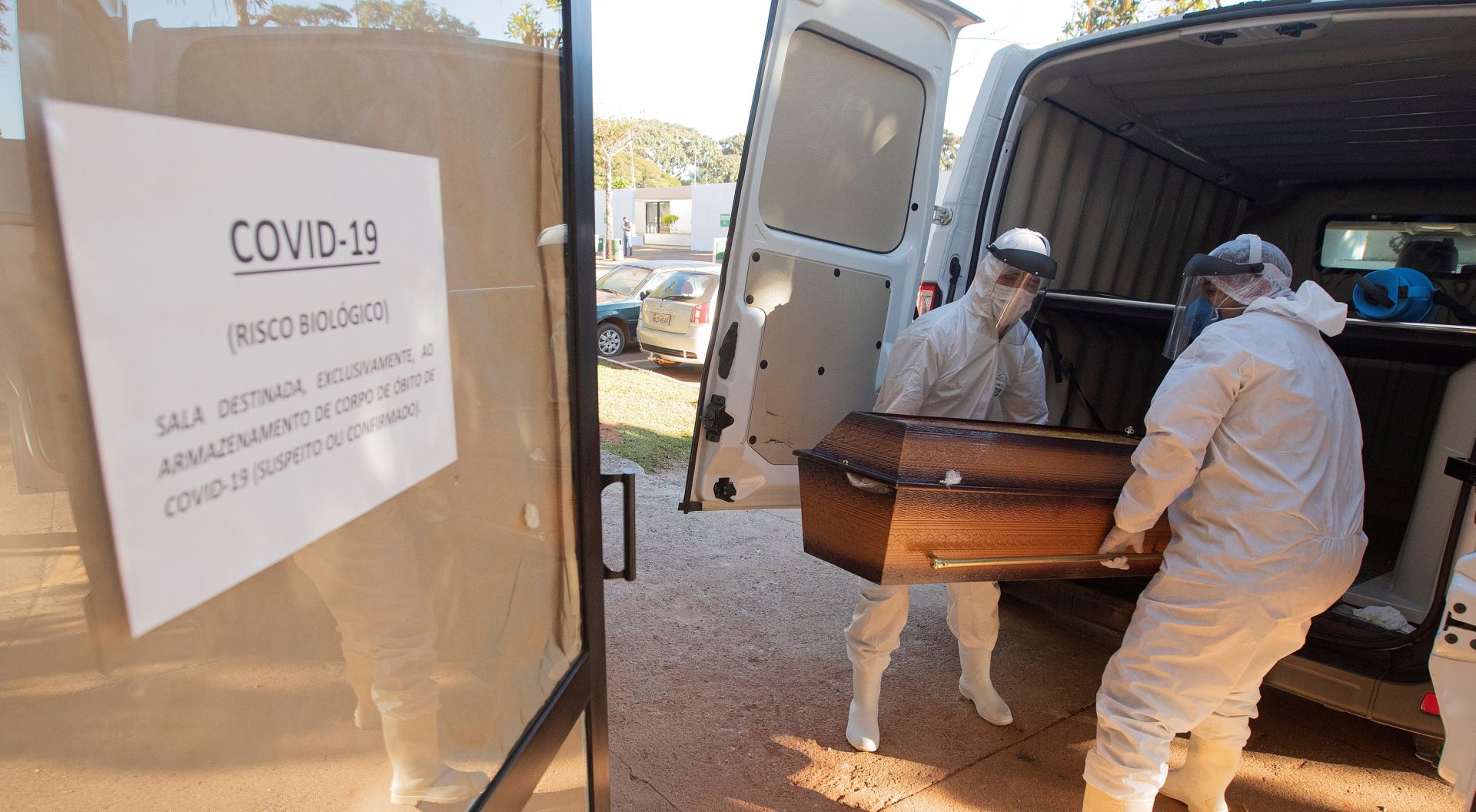 epa08477397 Funeral workers move caskets of coronavirus fatalities to a separate location, prior to burial at the Campo da Esperança cemetery in Brasilia, Brazil, 10 June 2020.  EPA/Joedson Alves