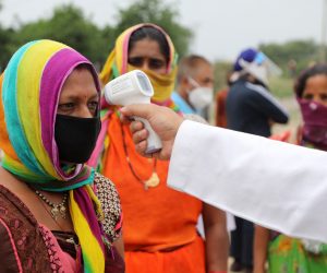 epa08478983 A health worker checks the body temperature of migrant labourers from Chhattisgarh state before sending them to their native places as they are stranded in an open ground, in Jammu, India, 11 June 2020. Hundreds of migrant labourers struck in Jammu who have left their rented houses to go back to their native places allege that the landlords are not allowing them to get back after they left the rented houses and now labourers along with families are spending nights in open ground from past five days.  EPA/JAIPAL SINGH
